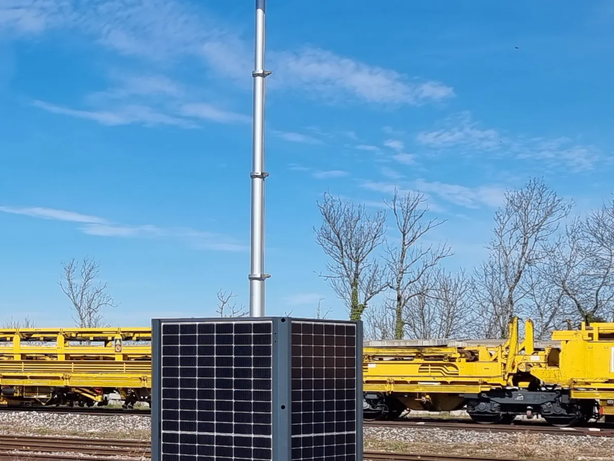 HELIGARD EVO autonomous solar tower: photovoltaic panels on the cabinet faces and telescopic mast, deployed along a railway corridor